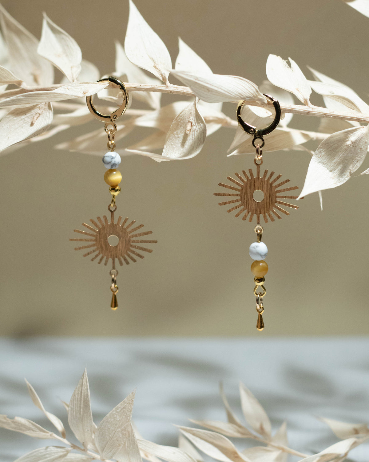 Boucles Cusco suspendues à une branche de fleurs séchées
